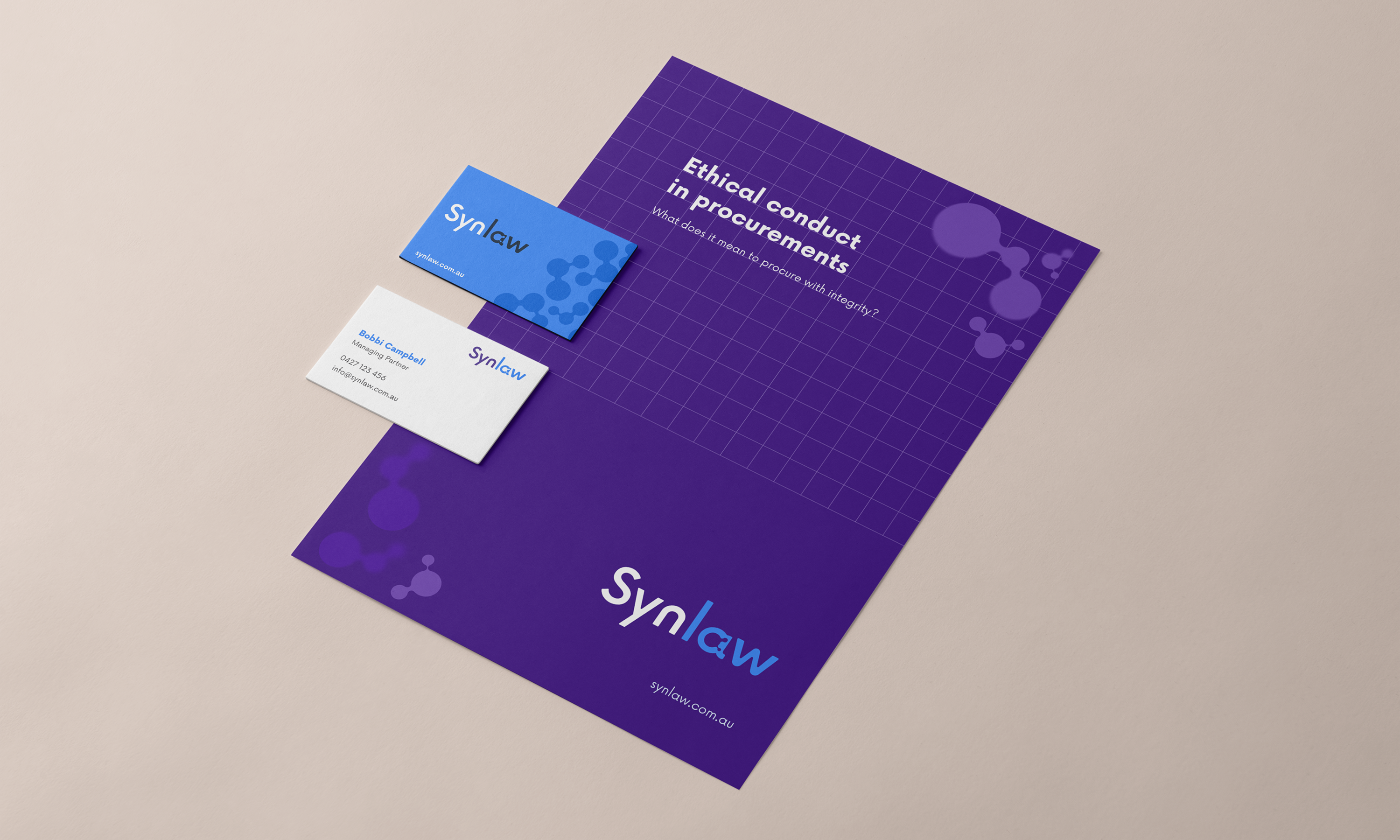 Synlaw letterhead and business cards laid out on a table, featuring the node motif and violet brand palette